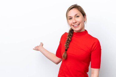 Beyaz arka planda soyutlanmış beyaz tenli genç bir kadın davet edilmek için ellerini yana uzatıyor.