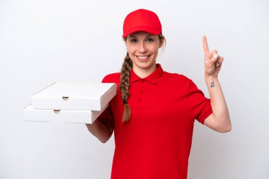 Pizza dağıtan kadın iş üniformalı beyaz arka planda izole edilmiş pizza kutularını alıyor ve en iyinin işareti olarak parmağını kaldırıyor.