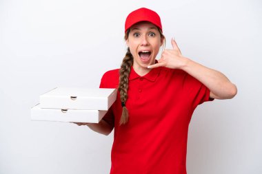 İş üniformalı bir pizzacı kadın beyaz arka planda izole edilmiş pizza kutularını alıyor ve telefon jesti yapıyor. Bana geri dönüş işareti ver.