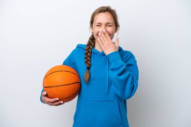 Beyazların arka planında basketbol oynayan beyaz bir kadın mutlu ve ağzı kapalı gülümsüyor.