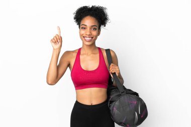 Spor çantalı genç Afro-Amerikan kadın mavi arka planda izole edilmiş harika bir fikre işaret ediyor.