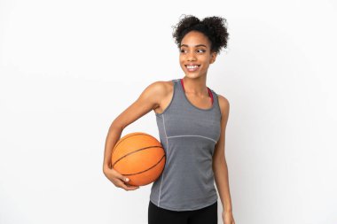Genç basketbolcu Latin kadın, beyaz arka planda izole edilmiş basketbol oynuyor.