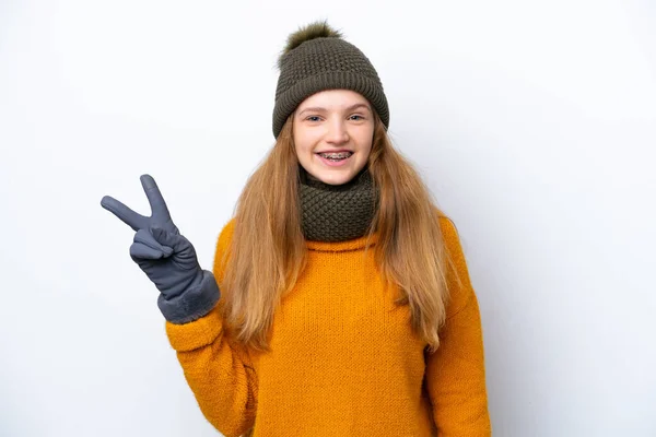 겨울용 자켓을 배경에 고립된 러시아 소녀가 웃으며 승리의 표시를 — 스톡 사진
