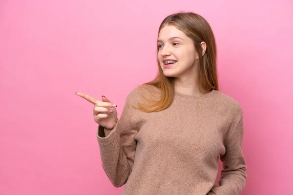 Έφηβη Ρωσίδα Απομονωμένη Ροζ Φόντο Δείχνοντας Δάχτυλο Στο Πλάι Και — Φωτογραφία Αρχείου