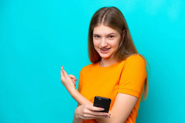 Ragazza Russa Adolescente Isolata Sfondo Blu Utilizzando Telefono Cellulare Puntando — Foto Stock