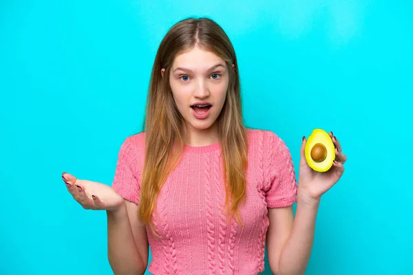 Teenager Russian Girl Holding Avocado Isolated Blue Background Shocked Facial — Stock Photo, Image