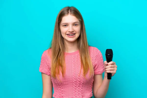 Cantante Chica Rusa Recogiendo Micrófono Aislado Sobre Fondo Azul Sonriendo — Foto de Stock