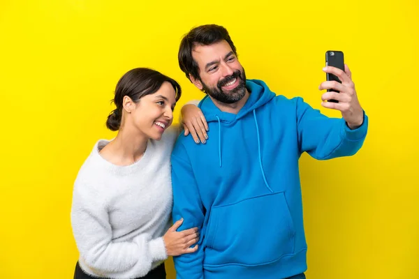 Joven Pareja Caucásica Aislada Sobre Fondo Amarillo Haciendo Una Selfie —  Fotos de Stock