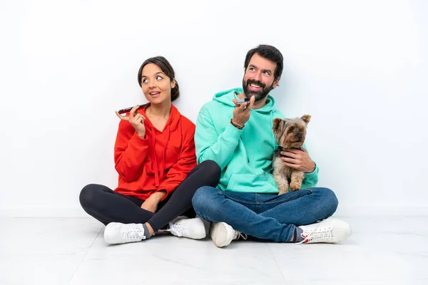 Young Caucasian Couple Sitting Floor Pet Isolated White Background Sending — Stock fotografie