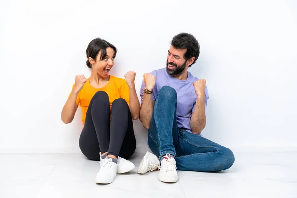 Young Caucasian Couple Sitting Floor Isolated White Background Celebrating Victory — Stock fotografie