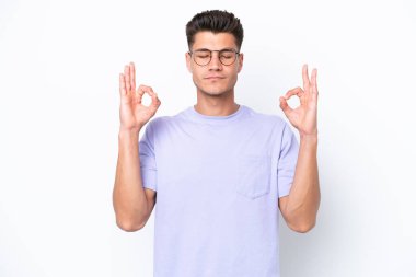 Beyaz arka planda Zen pozisyonunda beyaz tenli genç bir adam