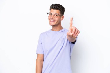 Beyaz arka planda izole edilmiş genç beyaz adam parmağını kaldırıyor ve gösteriyor.