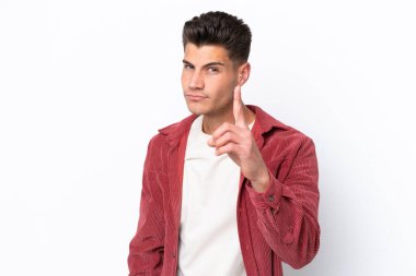 Beyaz arka planda izole edilmiş genç beyaz adam hayal kırıklığına uğramış ve ön tarafı işaret ediyor.