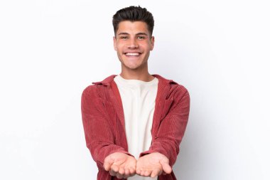 Beyaz arka planda izole edilmiş genç beyaz bir adam bir ilan vermek için avucunun içinde hayali bir fotokopi makinesi tutuyor.