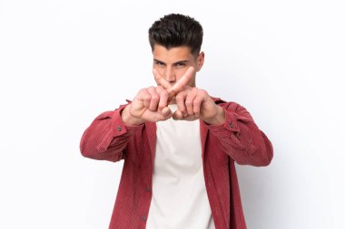 Beyaz arka planda izole edilmiş genç beyaz bir adam bir eylemi durdurmak için eliyle jesti durduruyor.