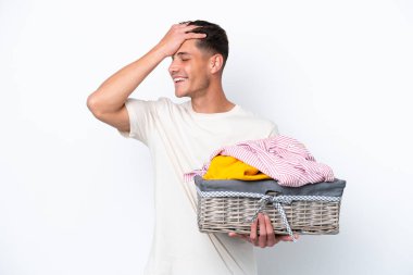 Beyaz arka planda çamaşır sepetini tutan genç beyaz adam bir şeyin farkına vardı ve çözüme niyetlendi.
