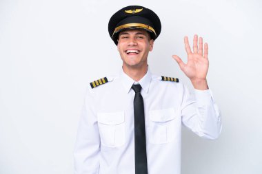 Kafkasyalı uçak pilotu beyaz arka planda izole edilmiş, mutlu bir ifadeyle selamlıyor.