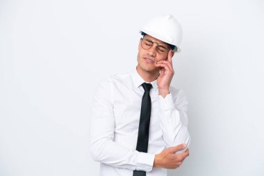 Miğferli ve elinde beyaz arka planda baş ağrısıyla izole edilmiş planlar tutan beyaz bir mimar.