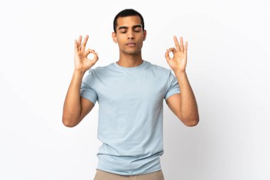 Zen pozunda izole edilmiş beyaz arka planı olan Afrikalı Amerikalı bir adam.