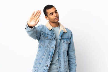 İzole edilmiş beyaz arka plan üzerinde Afrikalı Amerikalı bir adam durdurma hareketi yapıyor ve hayal kırıklığına uğruyor