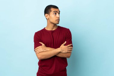 Omuzlarını kaldırırken şüpheyle hareket eden izole bir geçmişi olan Afrikalı Amerikalı adam.