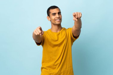 İzole edilmiş arka planda yaşayan Afrikalı Amerikalı adam mutlu bir ifadeyle öne bakıyor.