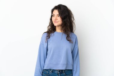 Beyaz arka planda izole edilmiş genç Rus kız yan tarafa bakıyor.