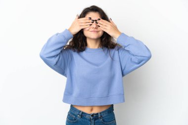 Beyaz arka planda izole edilmiş genç bir Rus kızı. Gözleri elleriyle kaplıyor ve gülümsüyor.