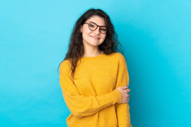 Genç Rus kız mavi arka planda tek başına gülüyor.