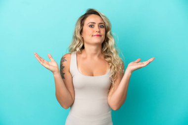 Mavi arka planda izole edilmiş genç Brezilyalı kadın şüpheli hareketler yapıyor.