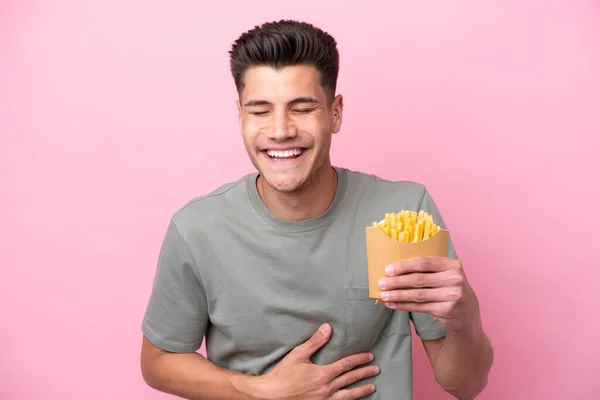 Młody Biały Mężczyzna Trzyma Smażone Chipsy Odizolowane Różowym Tle Uśmiechając — Zdjęcie stockowe