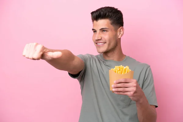 Young Caucasian Man Holding Fried Chips Isolated Pink Background Giving — Stockfoto