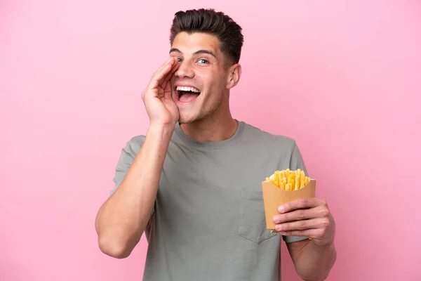 Jonge Kaukasische Man Met Gebakken Chips Geïsoleerd Roze Achtergrond Schreeuwen — Stockfoto