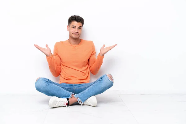 Young Man Sitting Floor Isolated White Background Having Doubts While — Stok fotoğraf