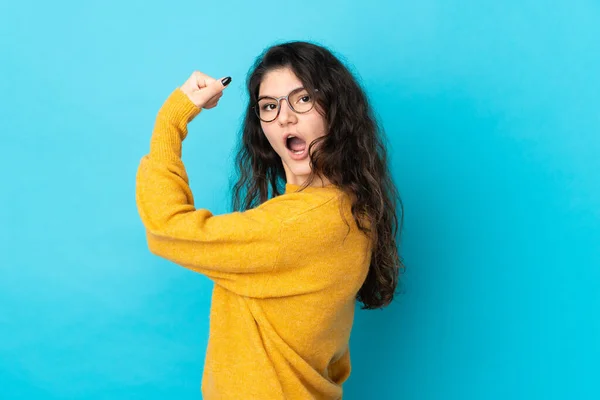 Adolescente Ruso Chica Aislado Azul Fondo Haciendo Fuerte Gesto —  Fotos de Stock