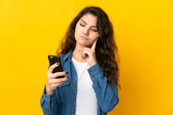 Έφηβη Ρωσίδα Απομονωμένη Κίτρινο Φόντο Χρησιμοποιώντας Κινητό Τηλέφωνο Και Σκέψη — Φωτογραφία Αρχείου
