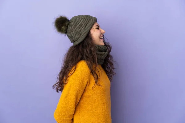 俄罗斯少女 头戴冬帽 背景紫色 侧面笑着 — 图库照片