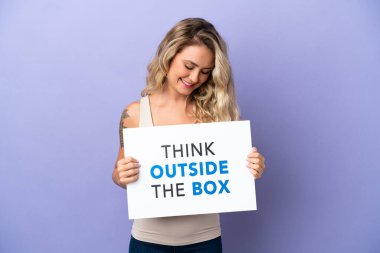Mor arka planda izole edilmiş genç Brezilyalı bir kadın elinde yazılı bir levhayla Kutunun Dışını Düşün