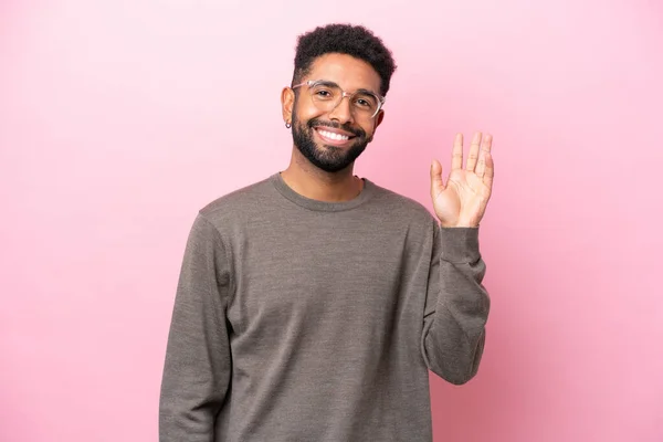 Νεαρός Βραζιλιάνος Άνδρας Απομονωμένος Ροζ Φόντο Χαιρετώντας Χέρι Χαρούμενη Έκφραση — Φωτογραφία Αρχείου