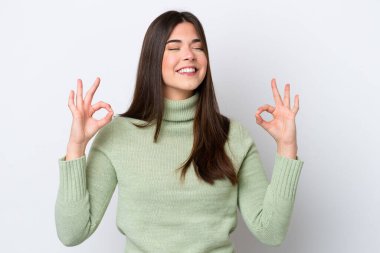 Zen pozunda beyaz arka planda izole edilmiş genç Brezilyalı kadın.