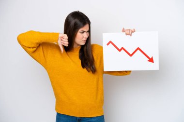 Beyaz arka planda izole edilmiş genç Brezilyalı bir kadın elinde azalan bir istatistik oku sembolü olan ve kötü sinyal veren bir tabela tutuyor.