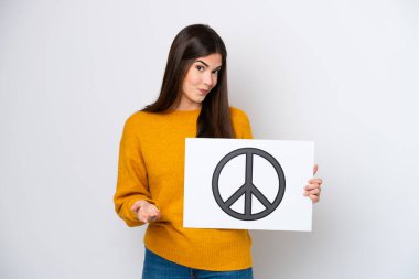 Genç Brezilyalı bir kadın beyaz arka planda izole edilmiş. Elinde barış sembolü olan bir pankart var.