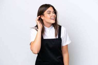 Restorandaki Brezilyalı garson kadın beyaz arka planda izole edilmiş bir şekilde elini kulağına koyarak bir şeyler dinliyor.