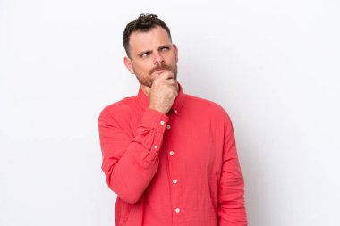 Beyaz arka planda izole edilmiş genç Brezilyalı adamın şüpheleri ve şaşkın bir yüz ifadesi var.