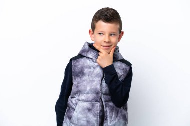 Beyaz arka planda izole edilmiş küçük bir çocuk yana bakıyor ve gülümsüyor.