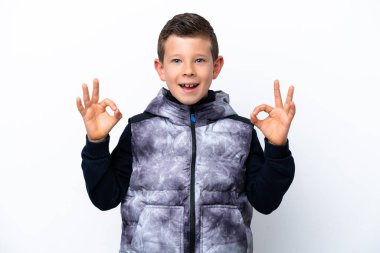 Beyaz arka planda izole edilmiş küçük çocuk iki eliyle tamam işareti gösteriyor.