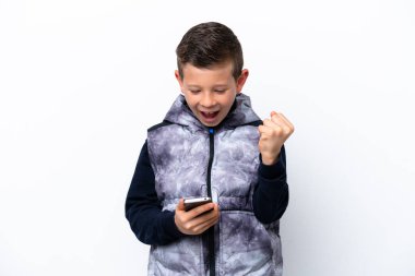 Küçük çocuk beyaz arka planda izole edilmiş ve telefon zafer pozisyonunda.