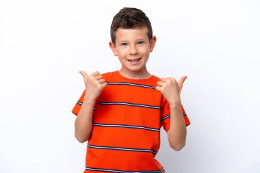 Beyaz arka planda izole edilmiş küçük bir çocuk. Baş parmakları havada ve gülümsüyor.