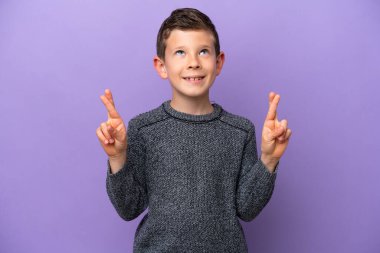 Küçük çocuk mor arka planda izole edilmiş, şans diliyor ve en iyisini diliyor.