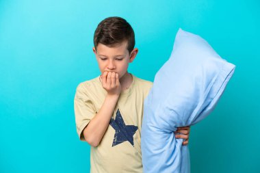 Mavi arka planda izole edilmiş pijamalı küçük bir çocuk şüpheleri var.